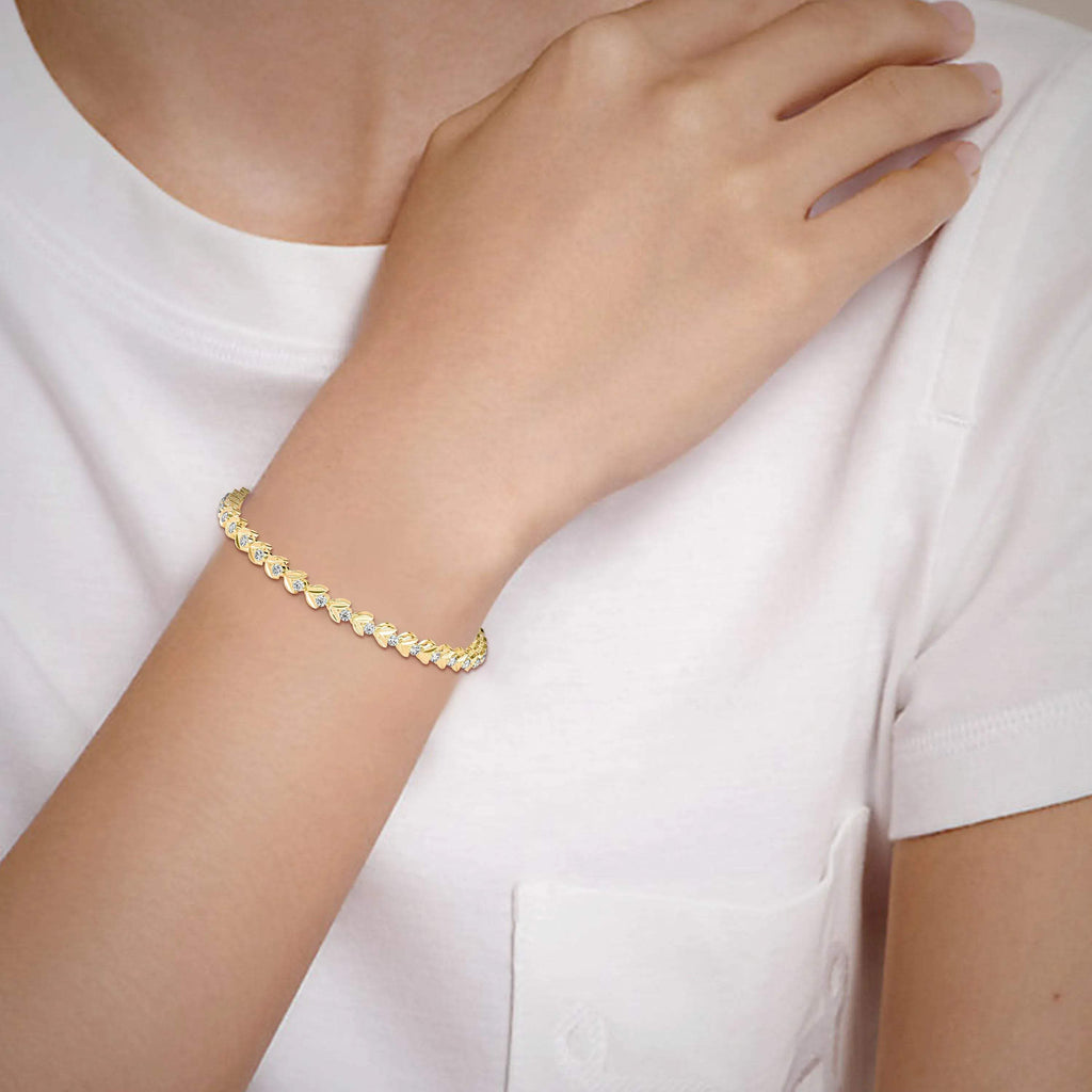 Gold and lab grown diamond bracelet on a person's wrist with a white background.