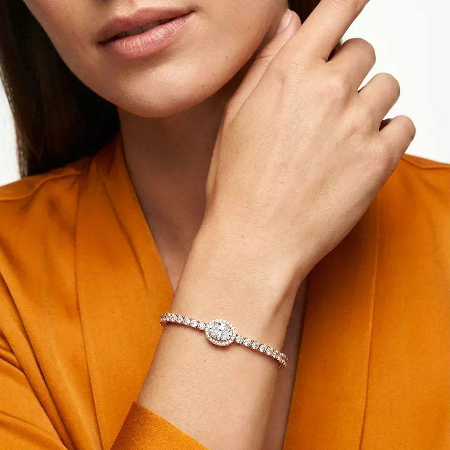 Close-up of a woman's hand wearing a lab grown diamond bracelet on an orange background