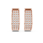 Rose gold huggies/hoops earrings with lab grown diamonds shown on a white surface.