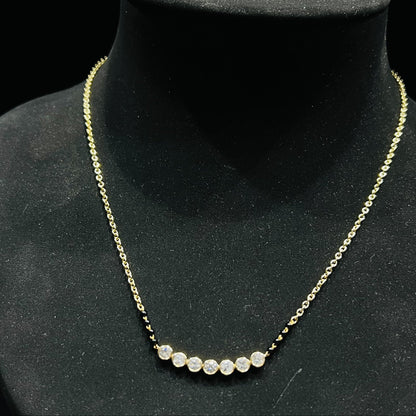 Gold and lab grown diamond mangalsutra with small round beads on a black mannequin bust