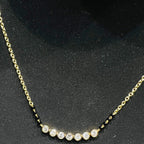 Gold mangalsutra with small round lab grown diamonds on a black background