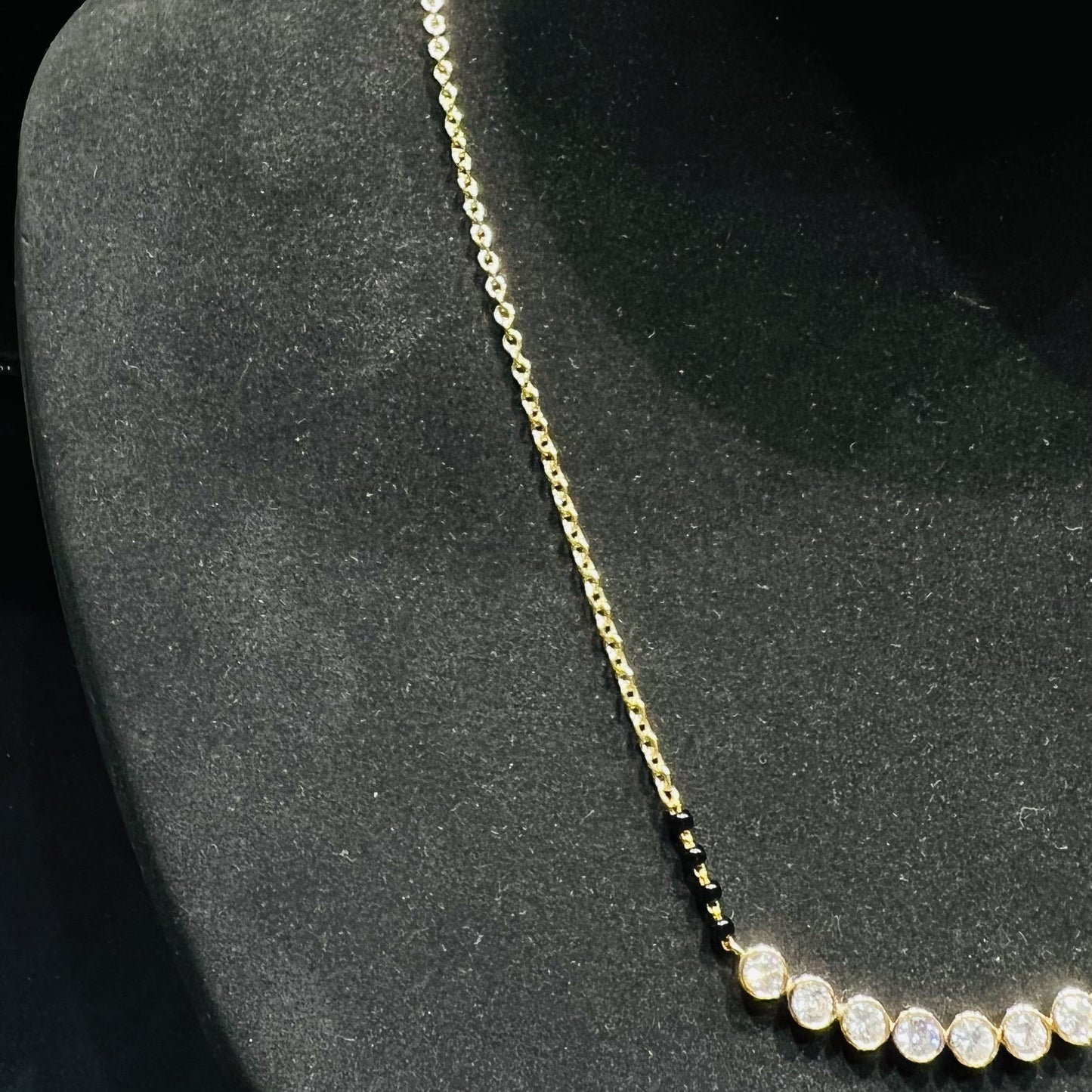 Gold and lab grown diamonds mangalsutra on a black mannequin bust