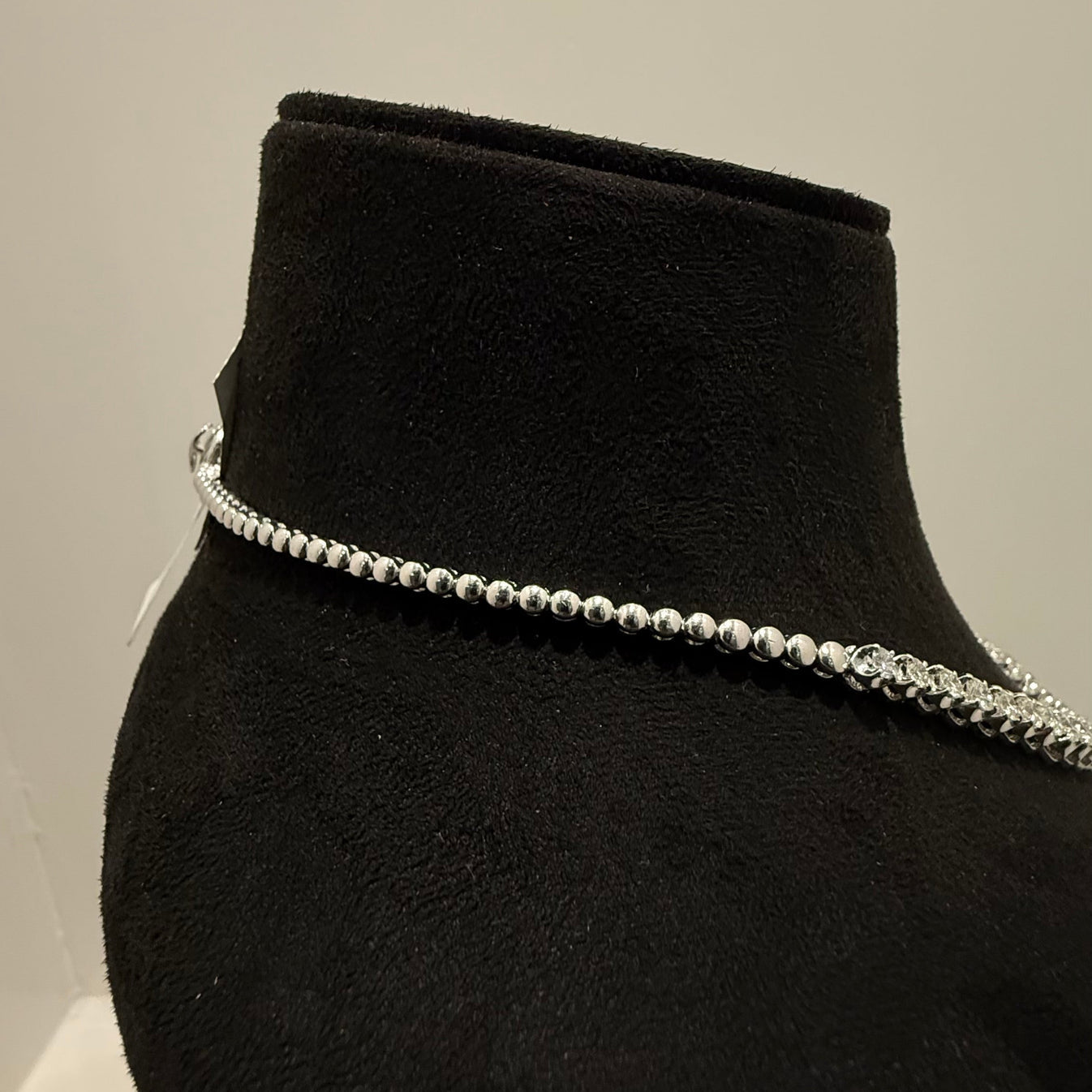 Elegant round cut lab grown diamond necklace set displayed on a black mannequin stand.