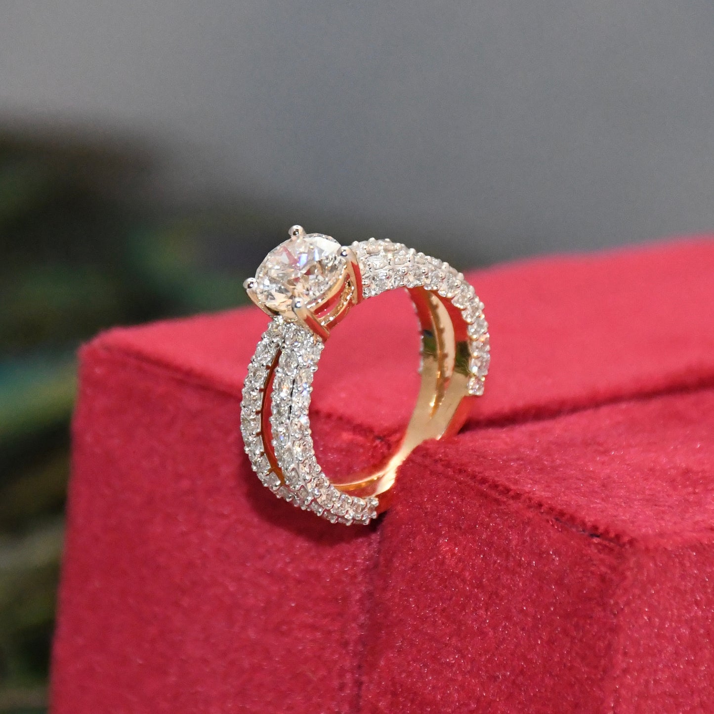 Gold and diamond ring on a red jewelry box with a blurred background