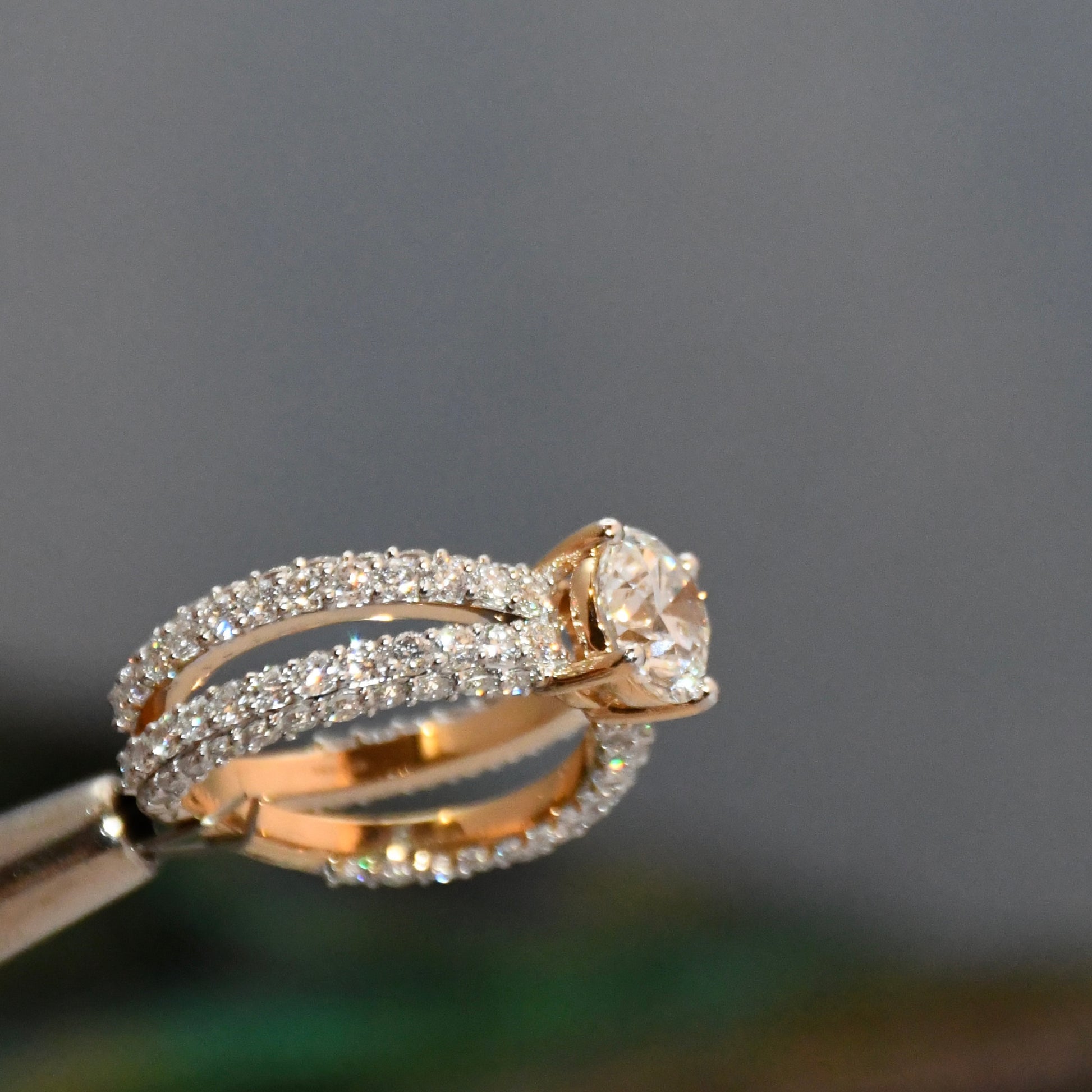 Rose gold ring with lab grown diamond accents on a dark background