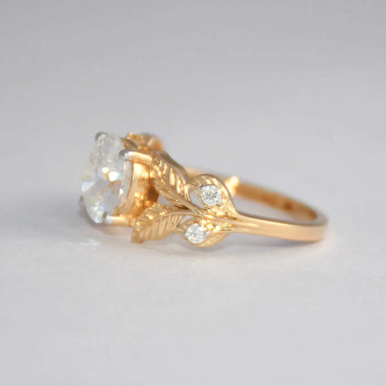 Gold ring with lab grown diamond on a gray background.