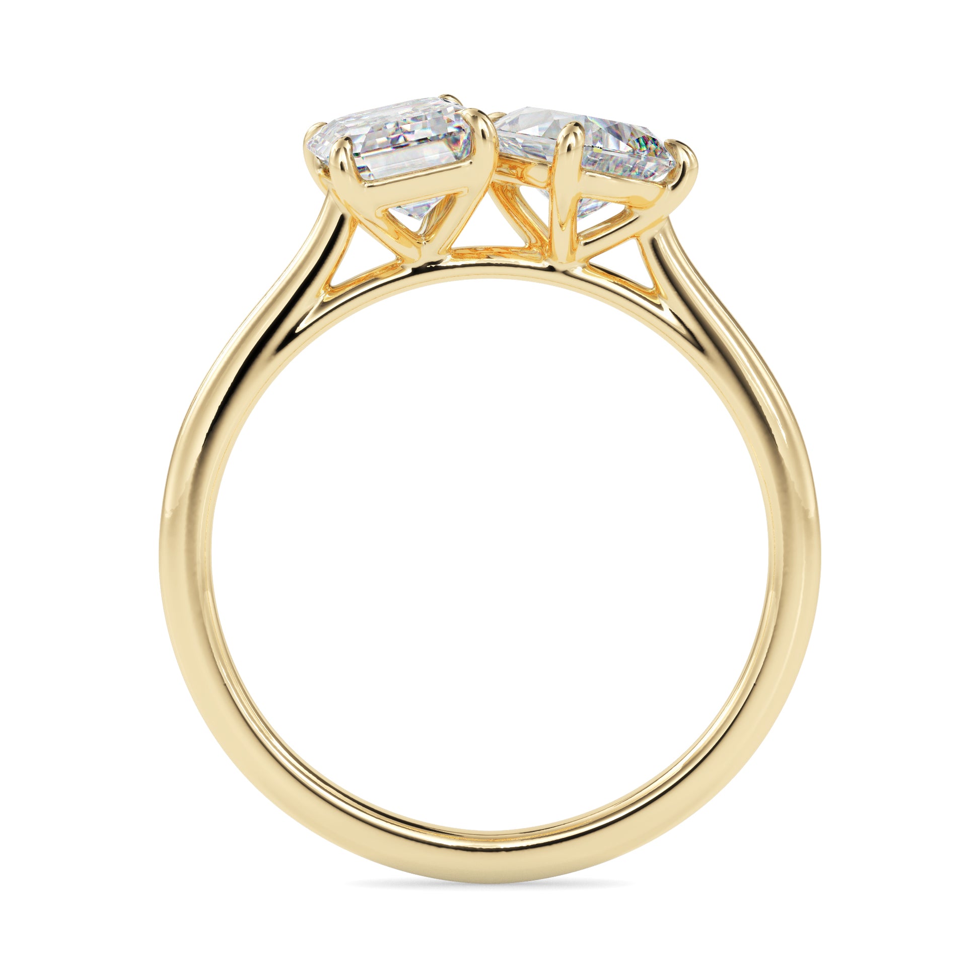 Gold ring with two lab grown diamonds- one pear shape and other baguette shape, on a white background.