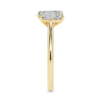 Gold ring with two lab grown diamonds- one pear shape and other baguette shape, on a white background.