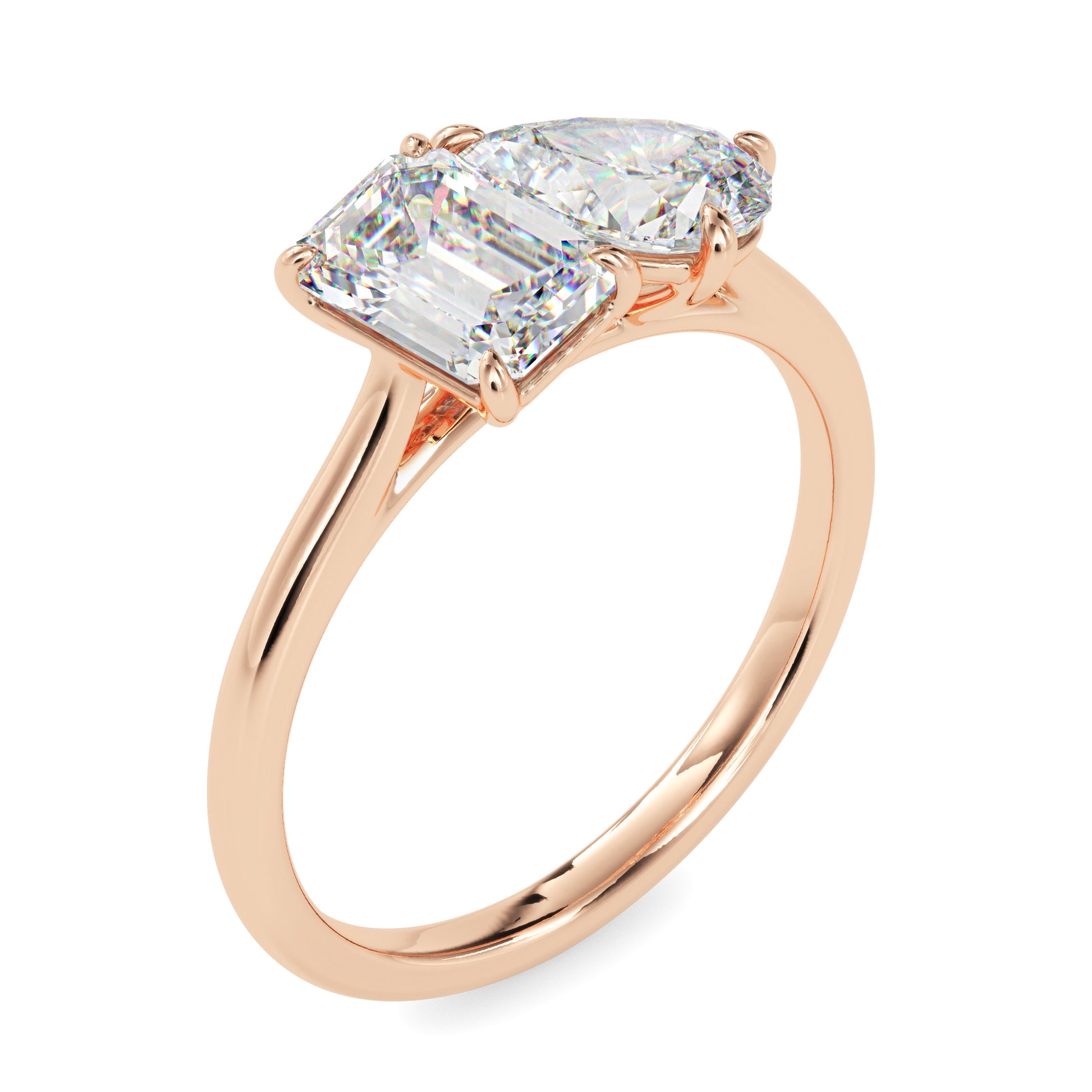 Rose gold ring with two lab grown diamonds- one pear shape and other baguette shape, on a white background.
