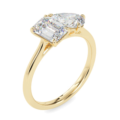 Gold ring with two lab grown diamonds- one pear shape and other baguette shape, on a white background