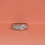 White gold ring with lab diamonds on a pink background