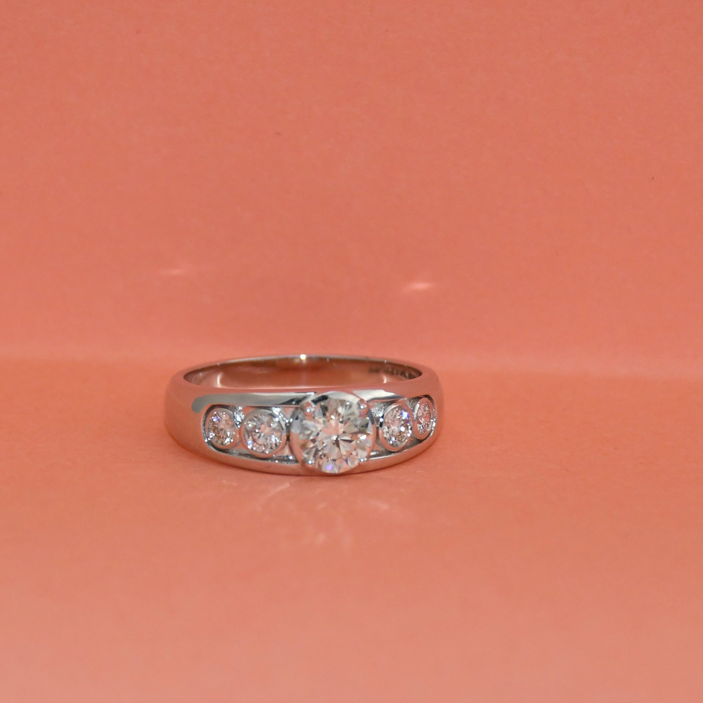 White gold ring with lab diamonds on a pink background