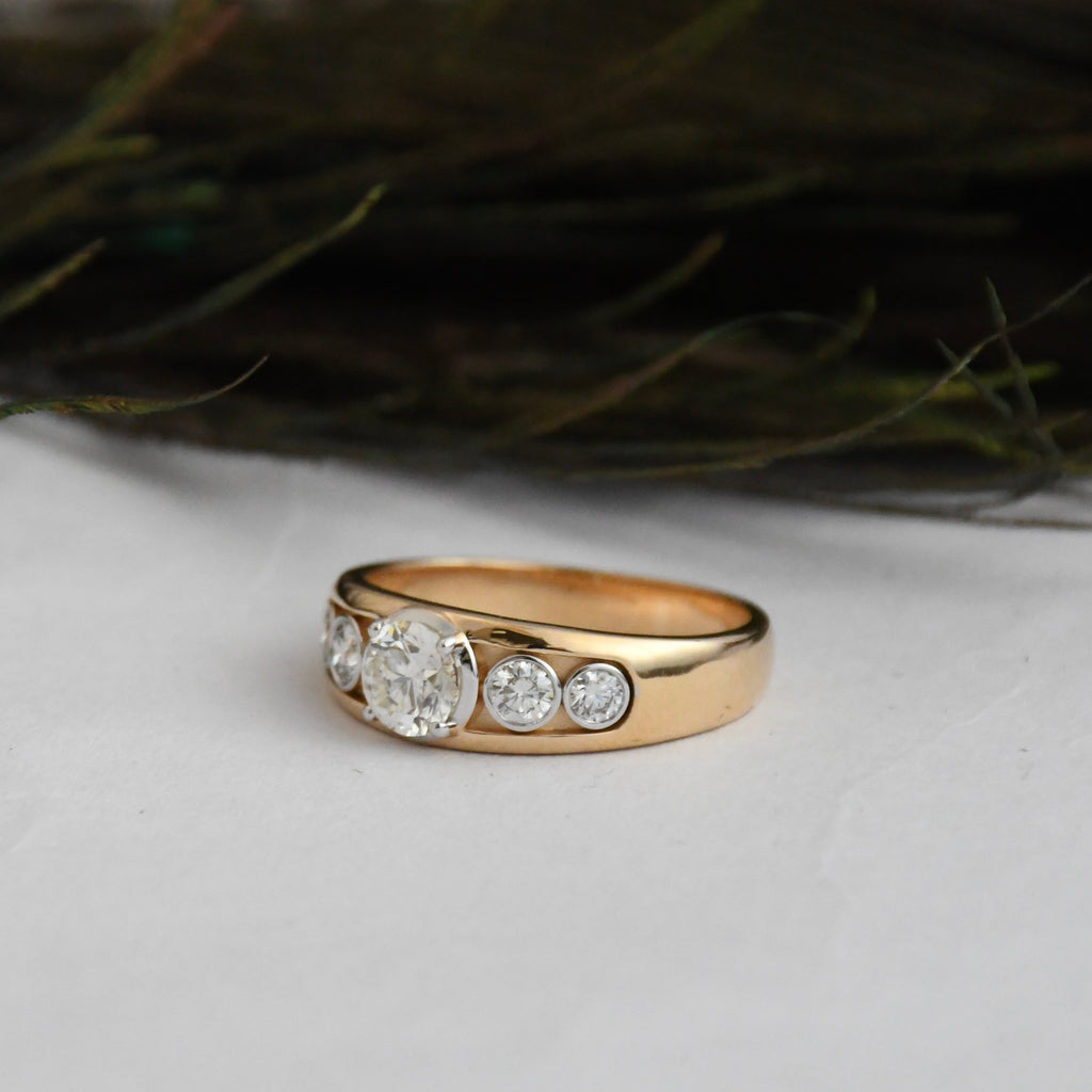Gold ring with lab diamonds on a light surface with a blurred natural background