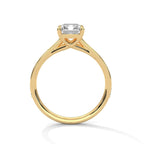 Gold ring with a large baguette-cut diamond and smaller diamonds on the band against a white background.