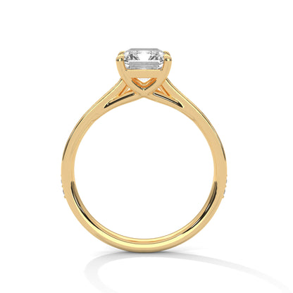 Gold ring with a large baguette-cut diamond and smaller diamonds on the band against a white background.