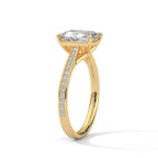 Gold ring with a large baguette-cut diamond and smaller diamonds on the band against a white background