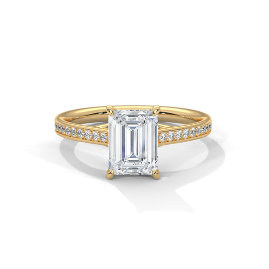 Gold ring with a large baguette-cut diamond and smaller diamonds on the band against a white background