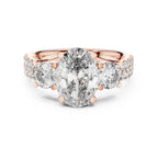 Rose gold ring with large lab diamonds and smaller diamonds on a white background