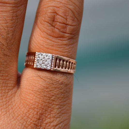 A man's hand displaying a gold diamond ring worn in his finger.