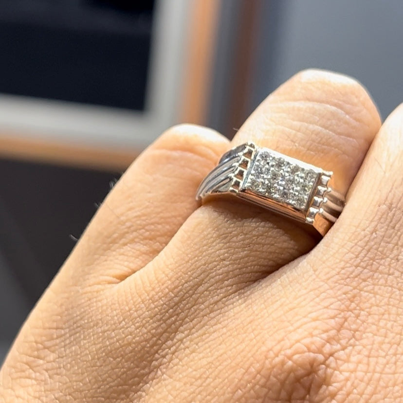 A man's hand displaying a diamond ring on his finger.