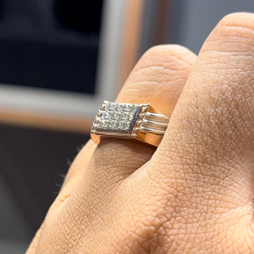 A man's hand displaying a diamond ring on his finger.