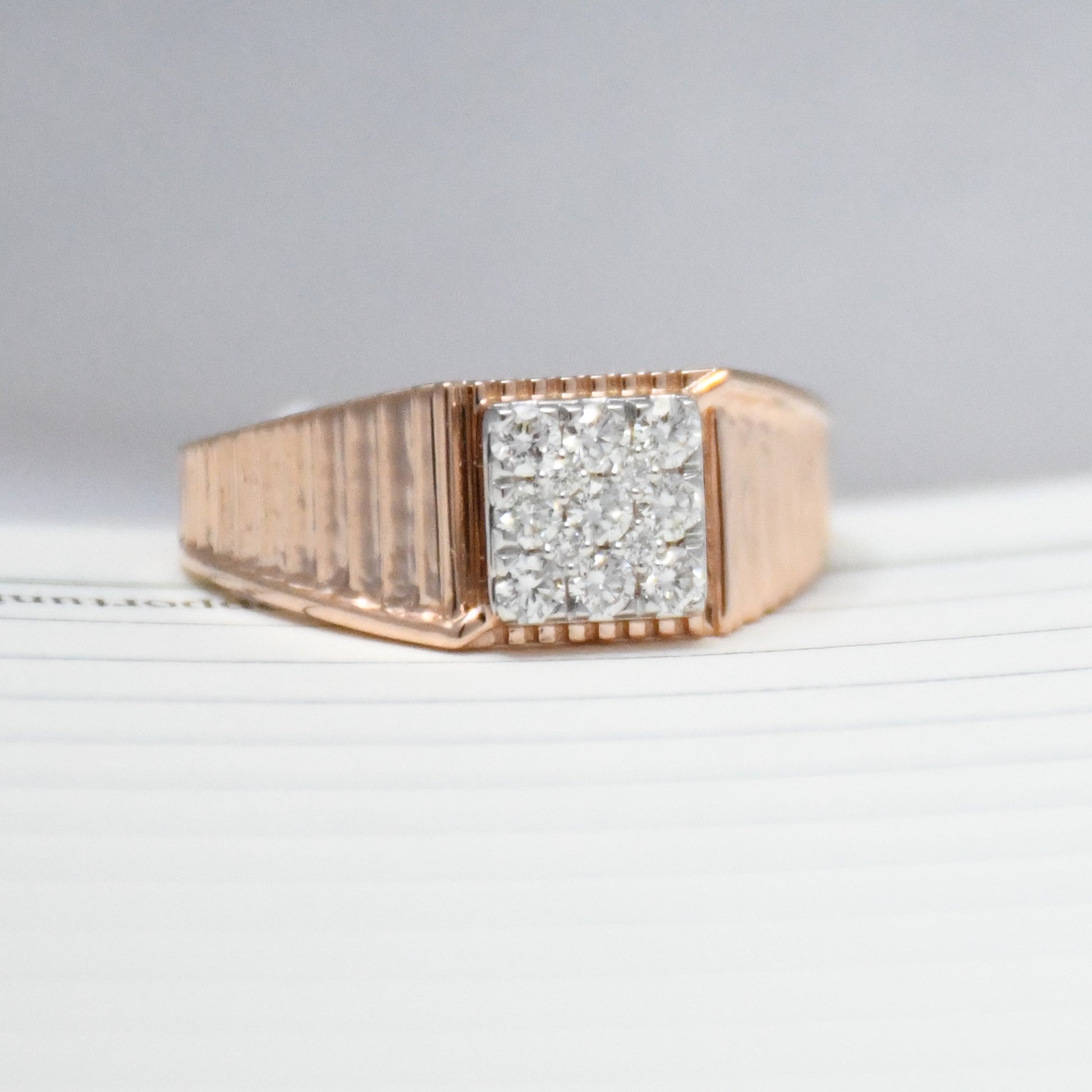 gold ring with diamonds on a light gray background