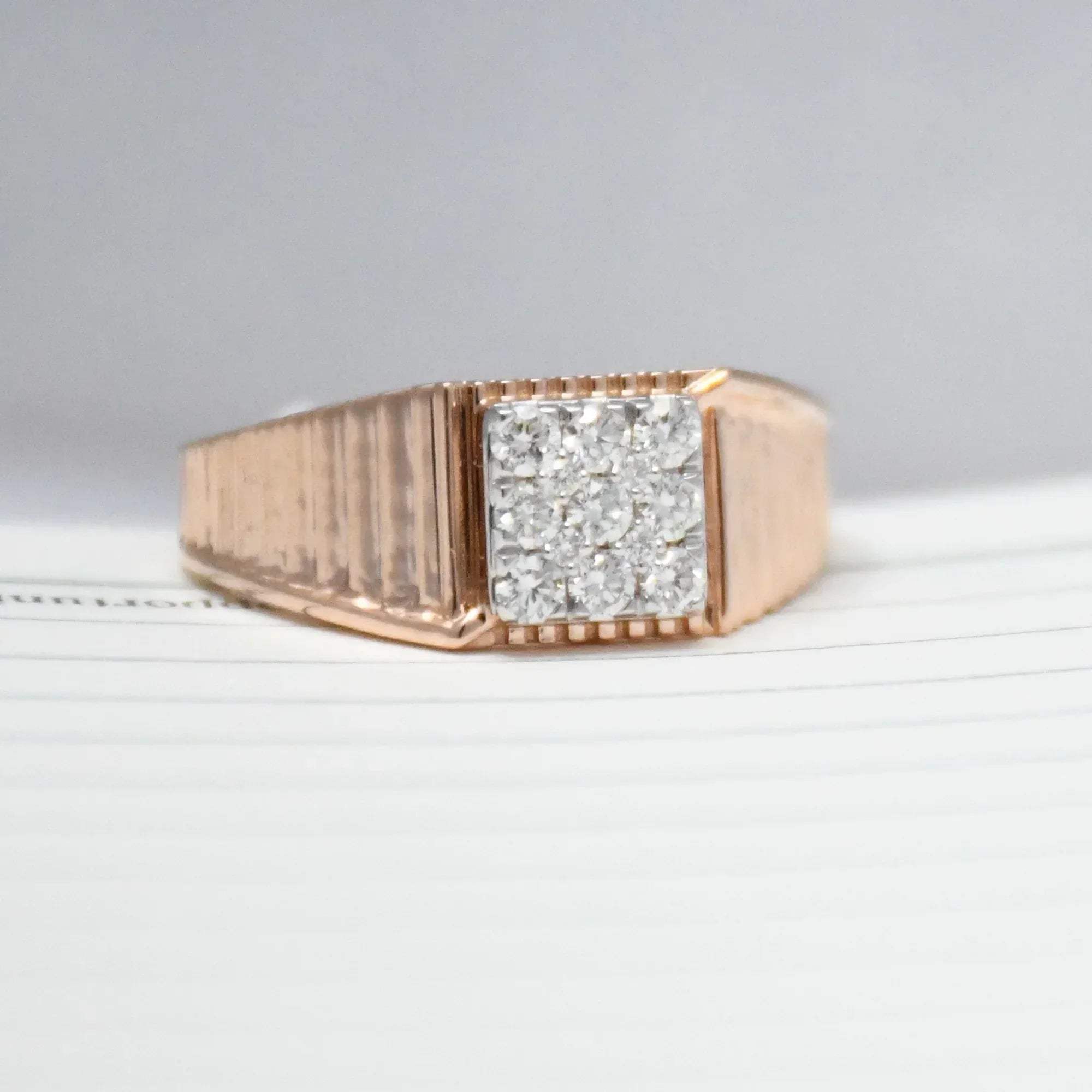 gold ring with diamonds on a light gray background