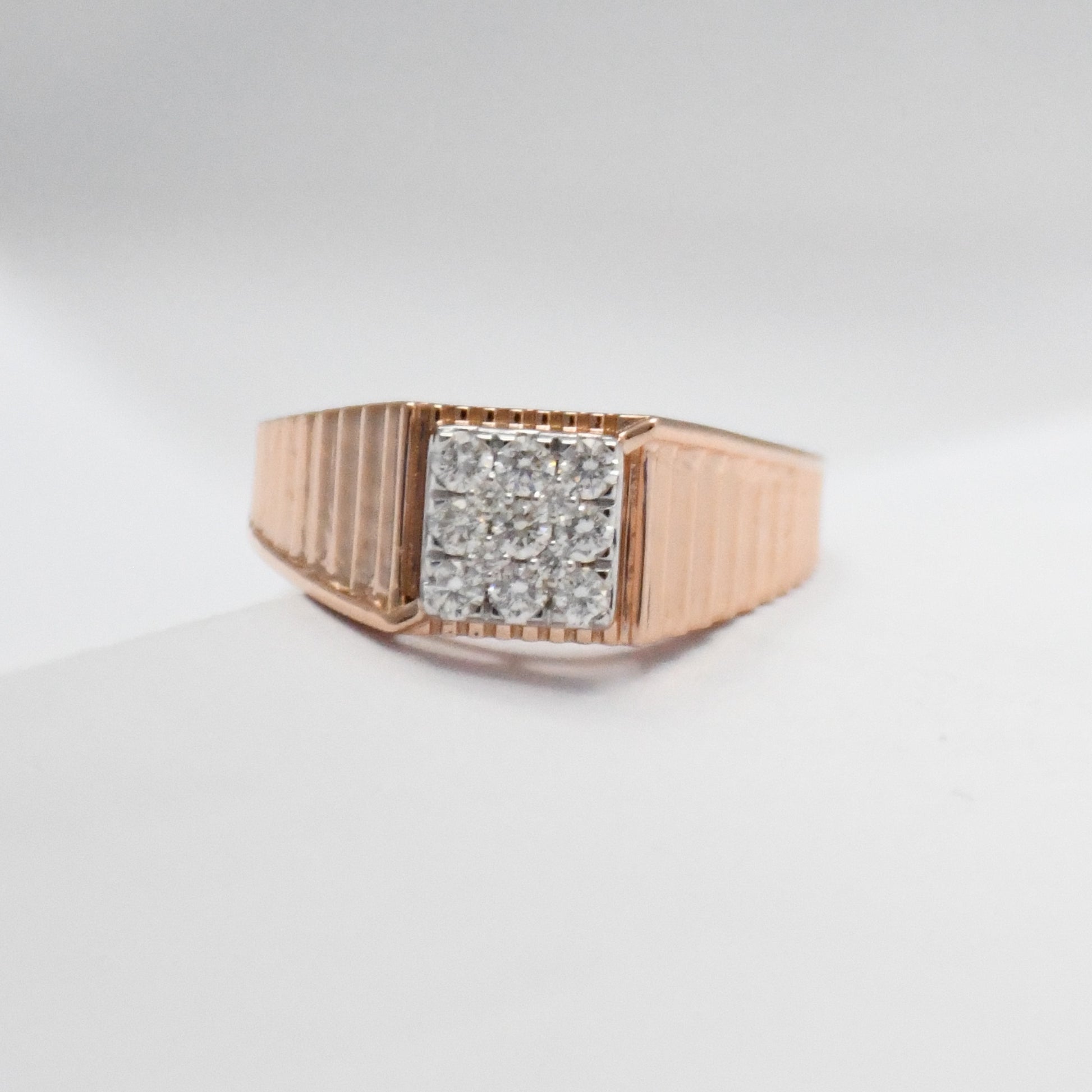 Rose gold ring with diamonds-encrusted band on a light gray background