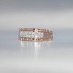 gold ring with embedded diamonds on a reflective surface