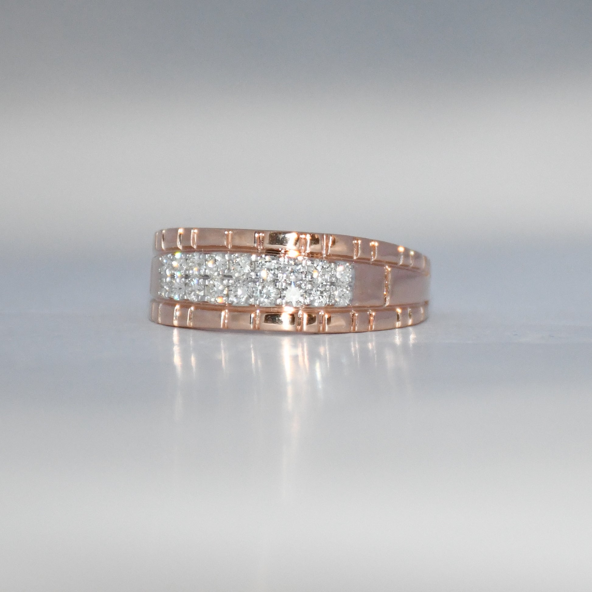 gold ring with embedded diamonds on a reflective surface
