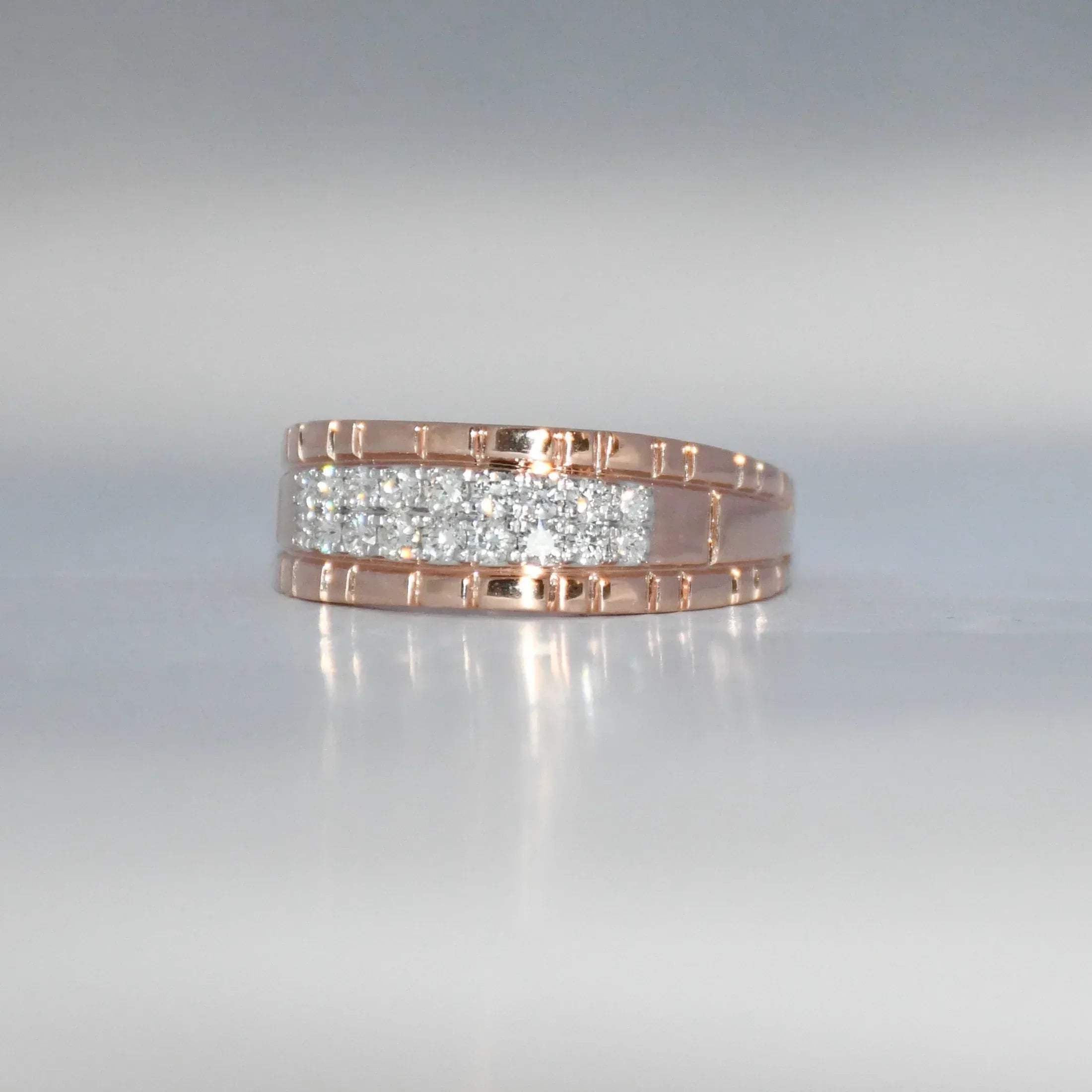 gold ring with embedded diamonds on a reflective surface