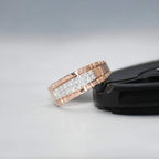 gold ring with diamonds on a black stand against a gray background
