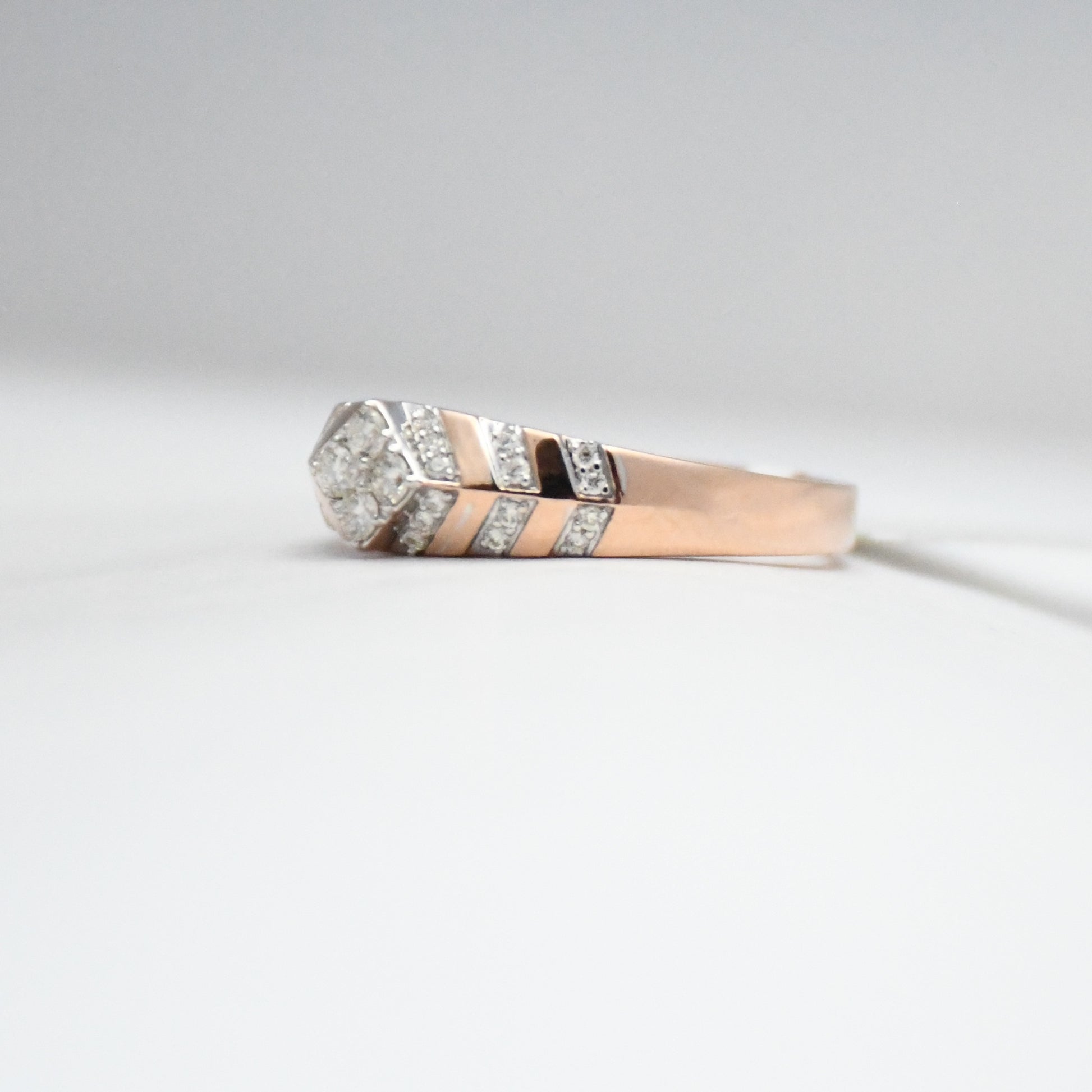 gold ring with diamond accents on a light gray background