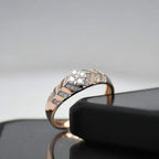 gold ring with diamonds on a reflective surface