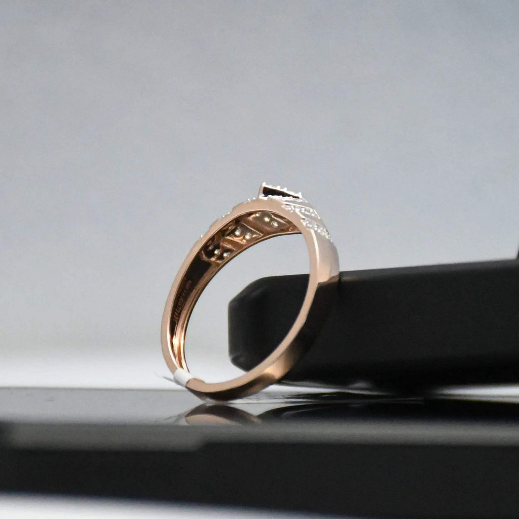 Rose gold ring with engraving on a reflective surface