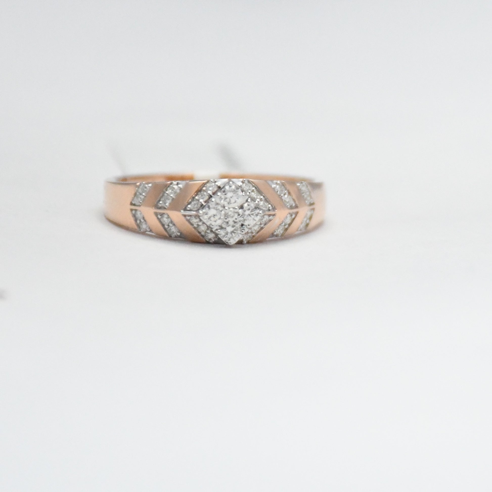 gold ring with diamond accents on a light gray background