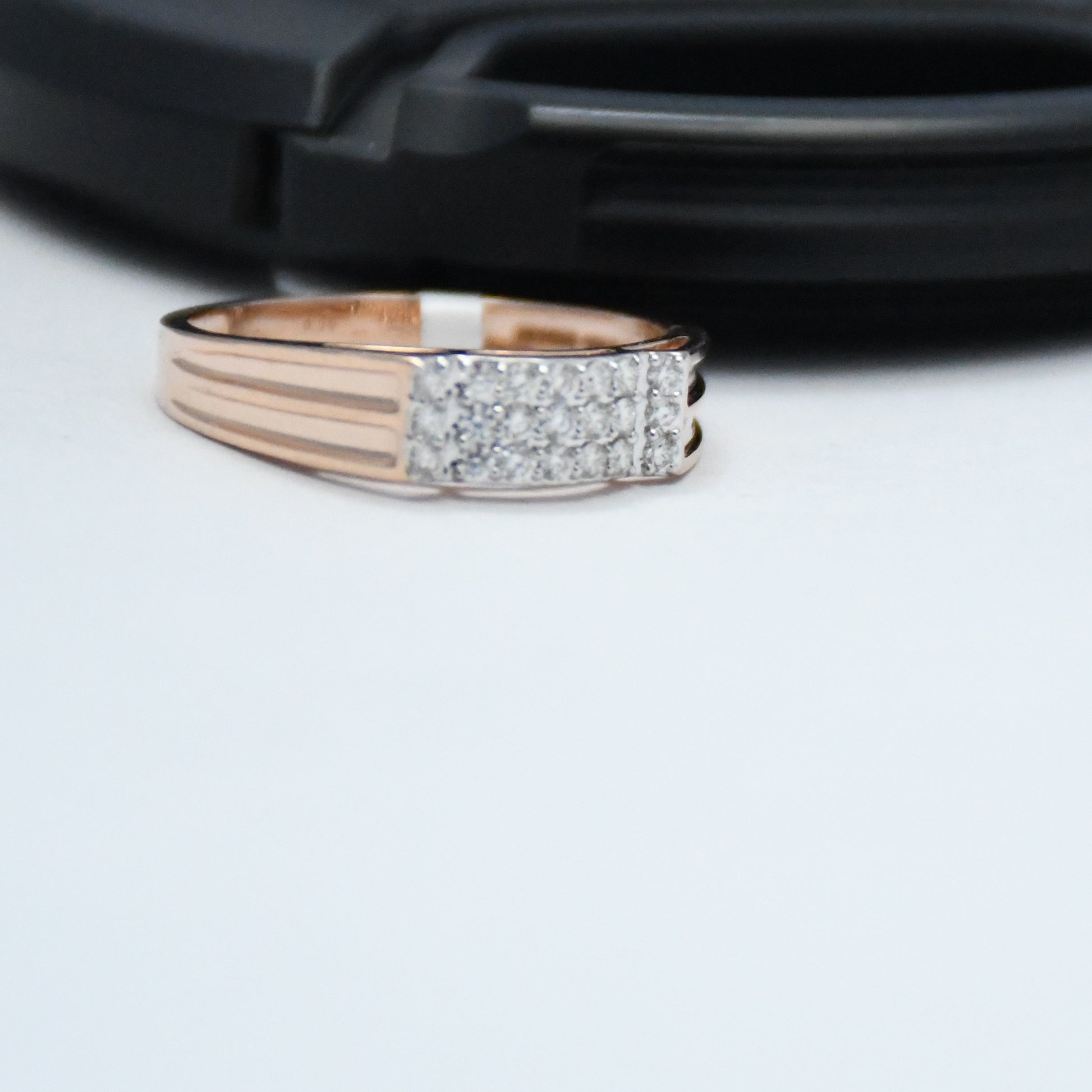 Rose gold ring with diamond accents on a white surface