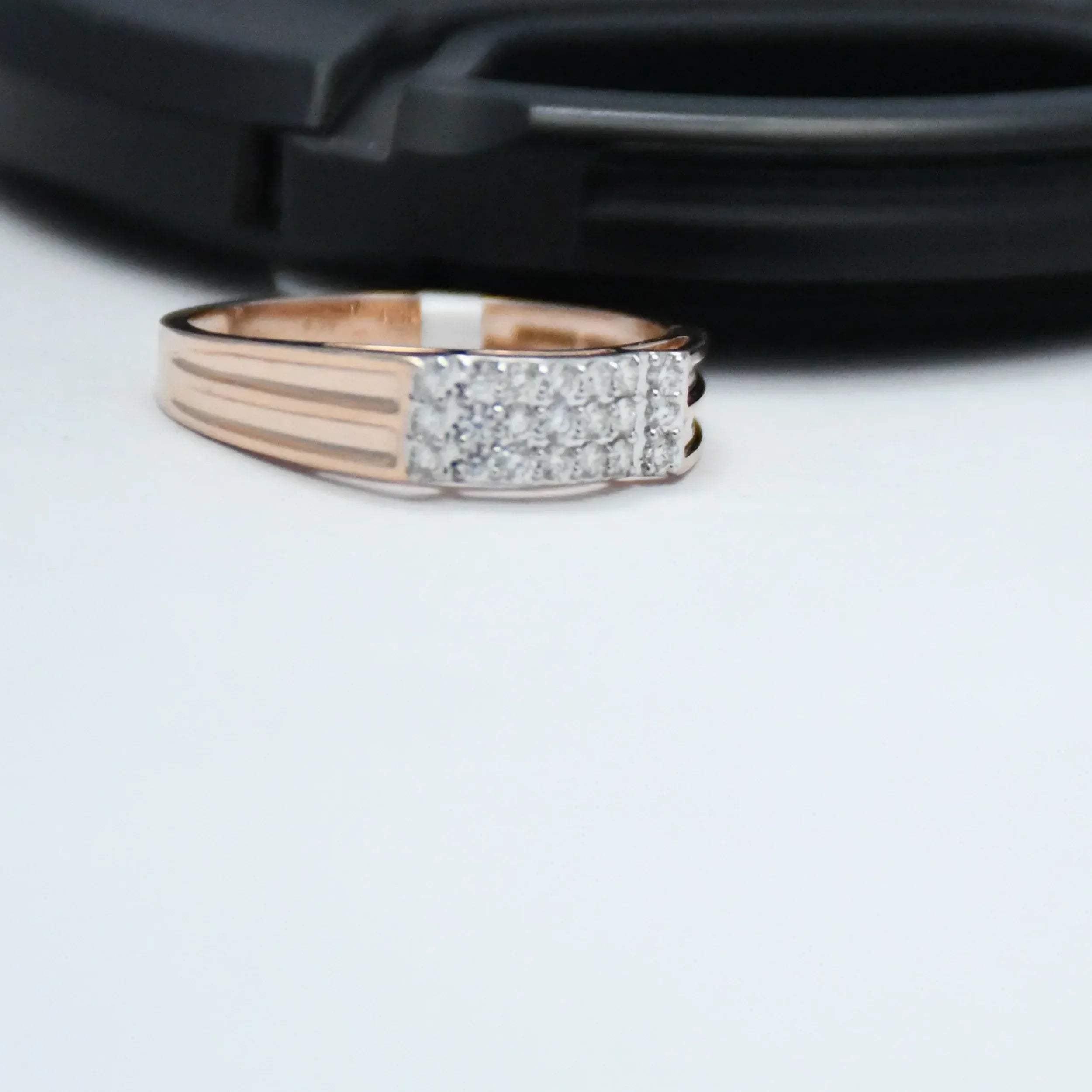 Rose gold ring with diamond accents on a white surface