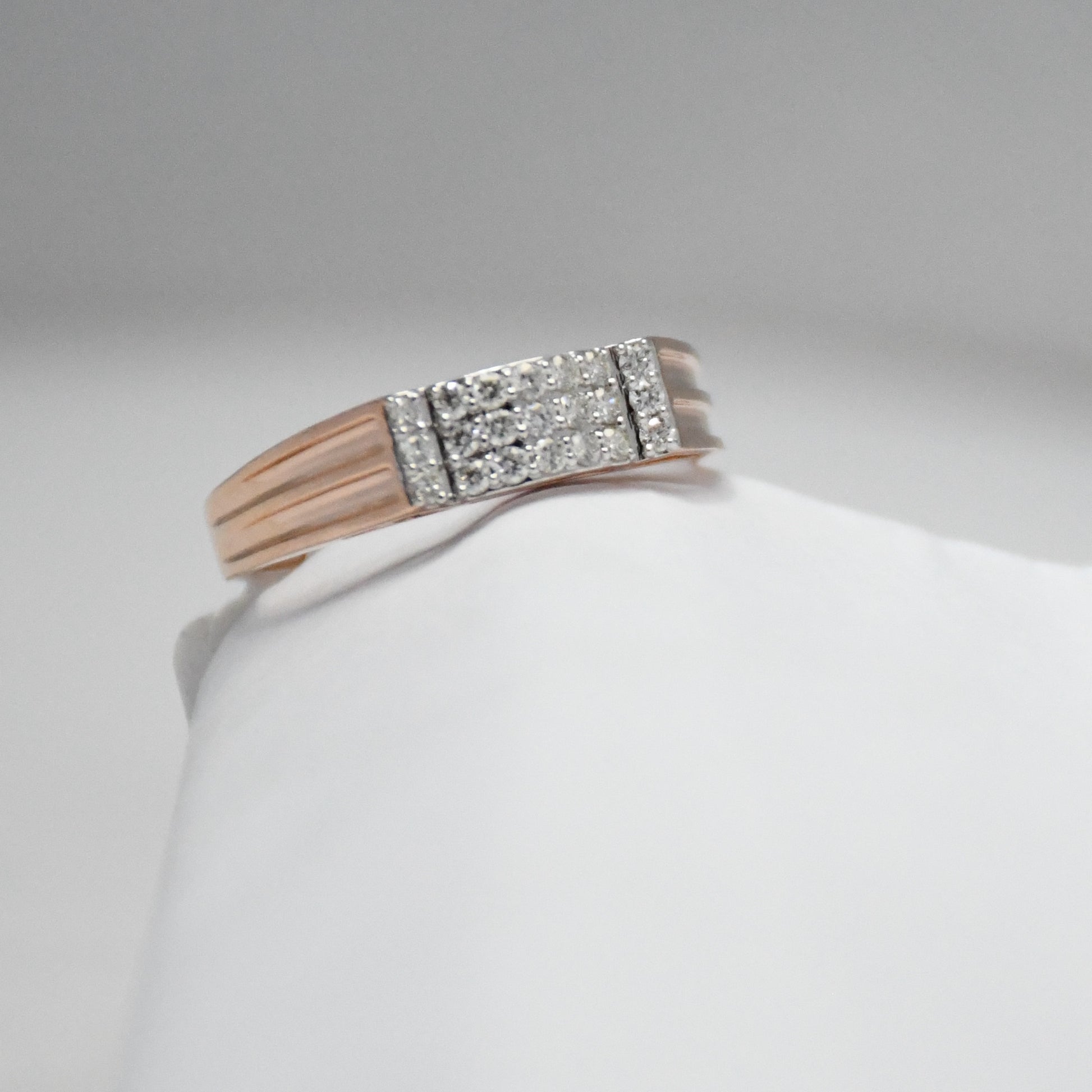 men's diamond ring with a gold band on a white mannequin arm against a gray background