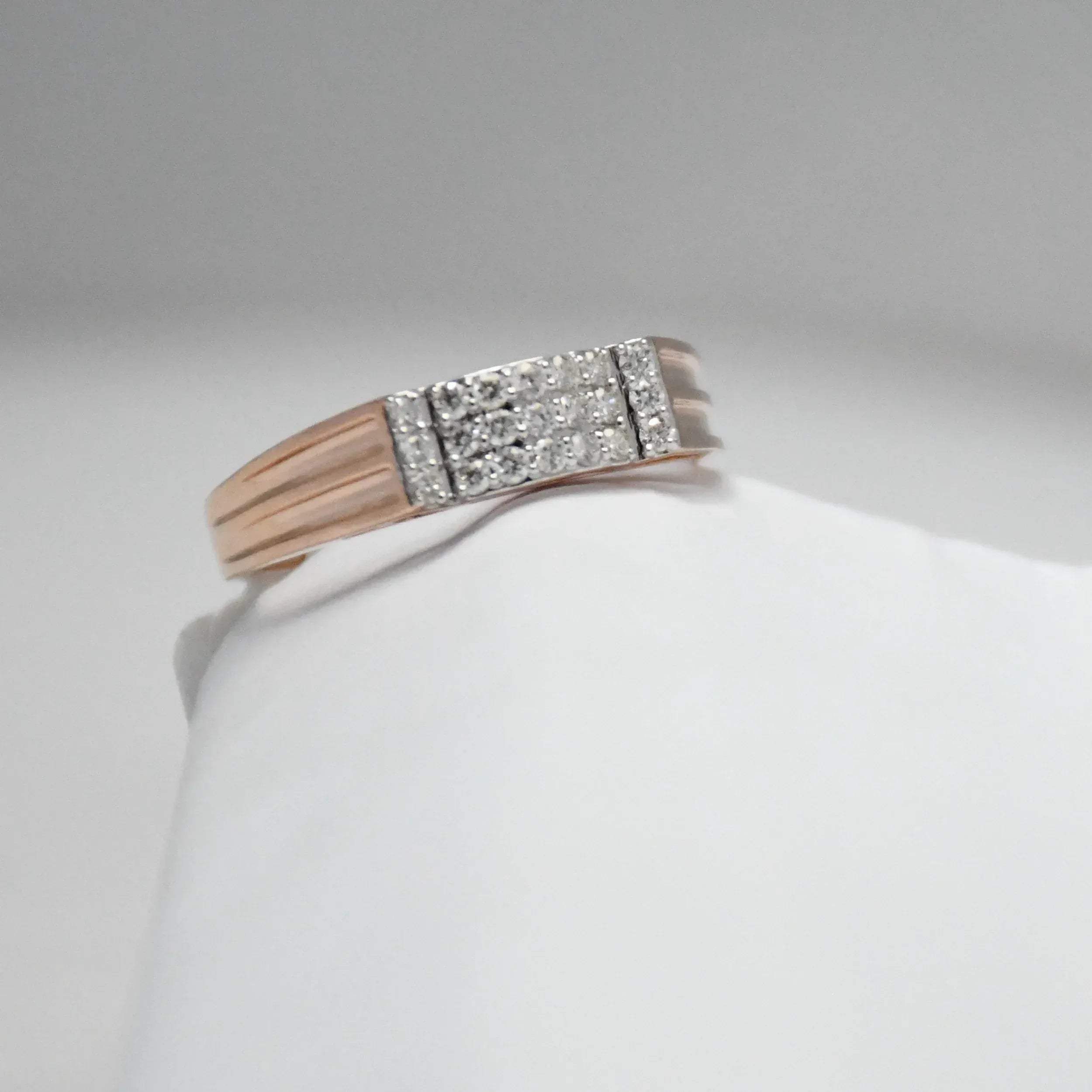 men's diamond ring with a gold band on a white mannequin arm against a gray background