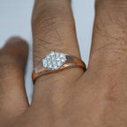 gold ring with a diamond on a person's finger against a white background