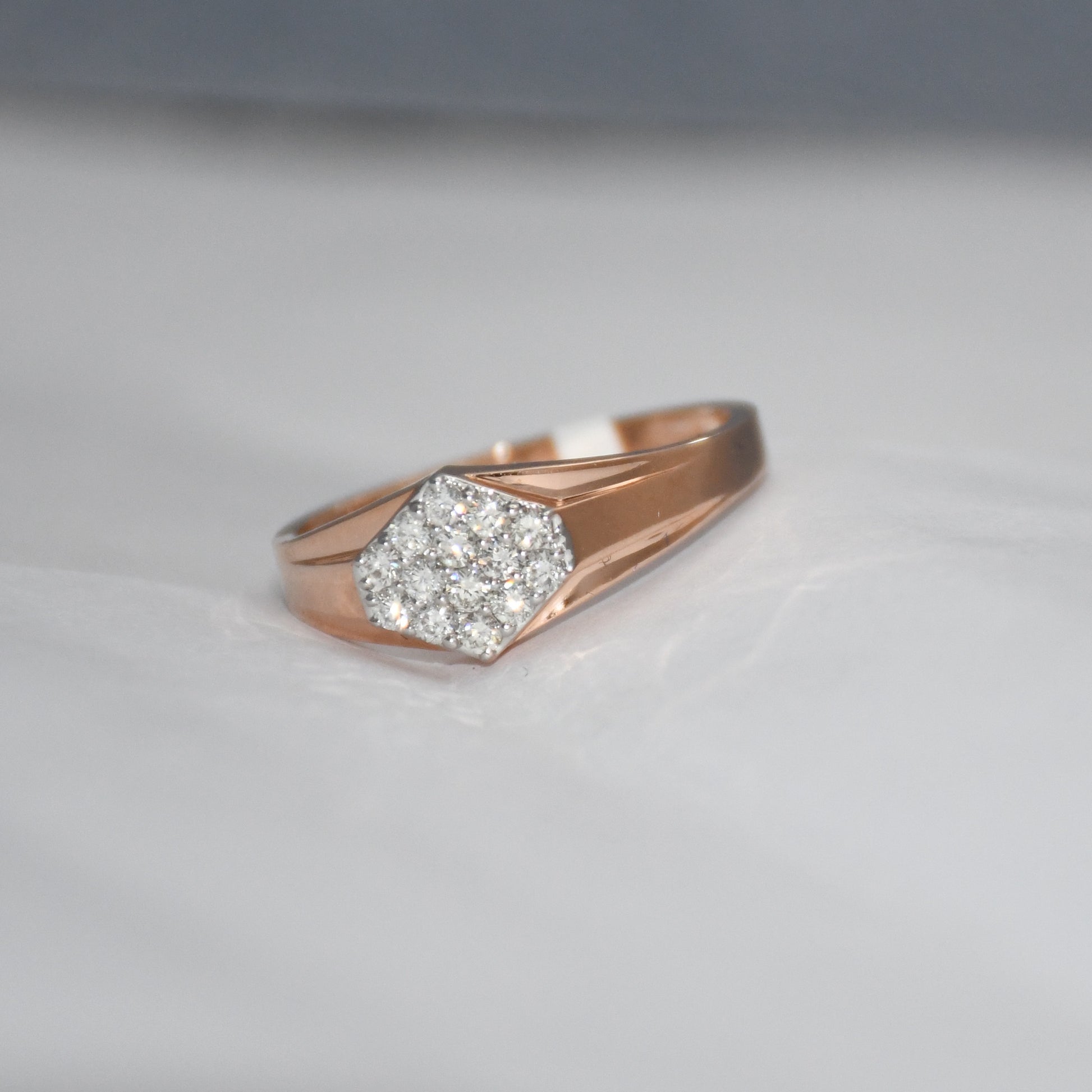 gold ring with diamond hexagonal design on a light gray background