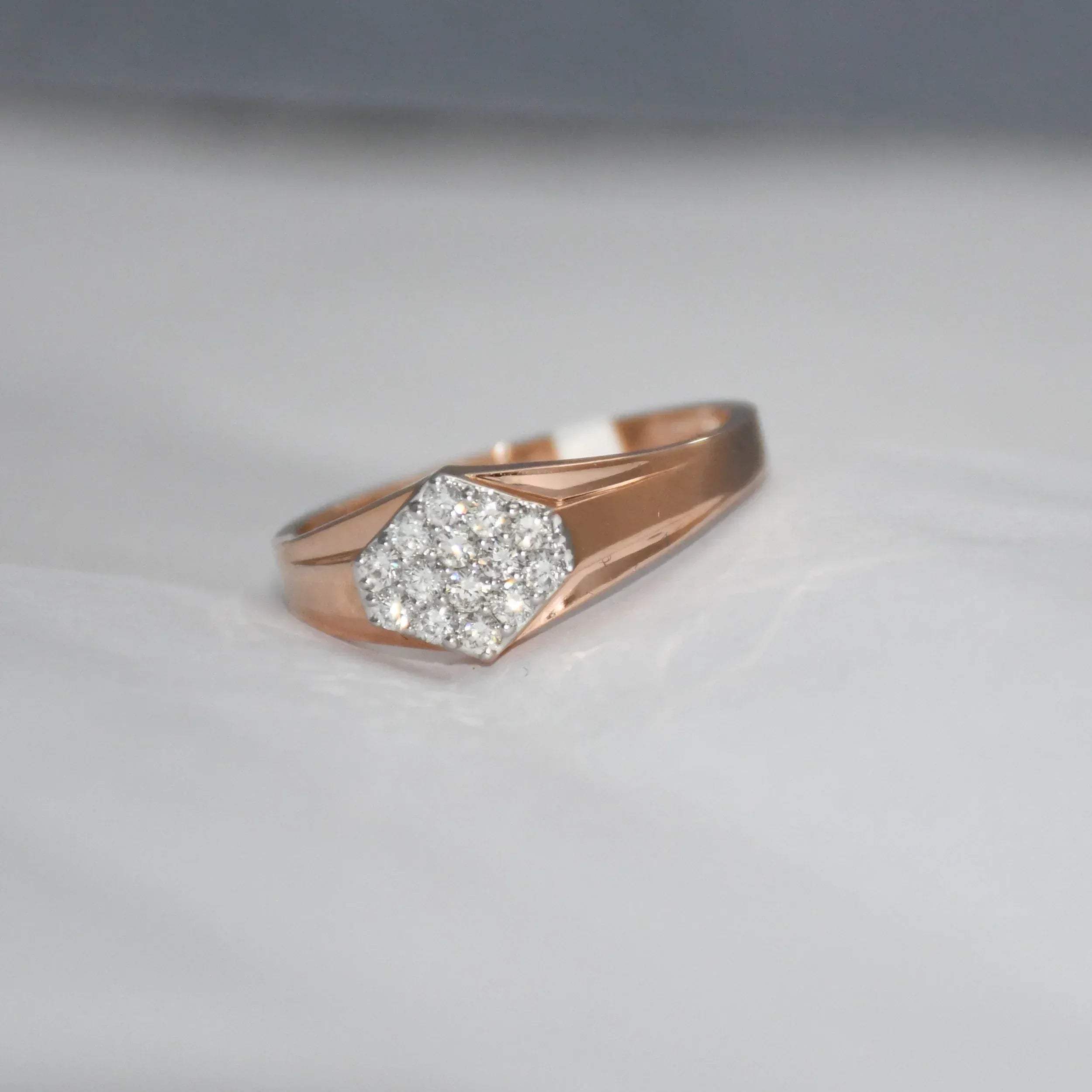 gold ring with diamond hexagonal design on a light gray background