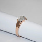 gold ring with a diamonds cluster on a white surface