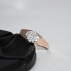 gold ring with diamond accent on a black stand against a light gray background