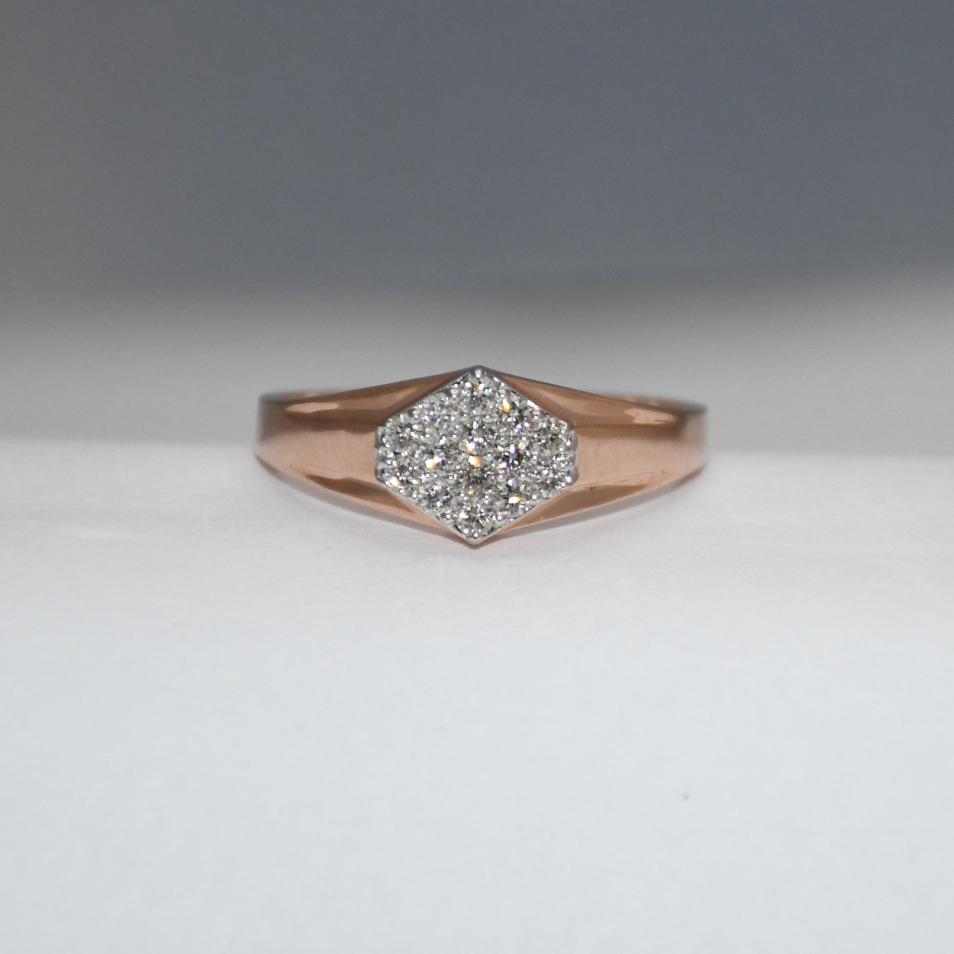 gold ring with diamond center on a gray background
