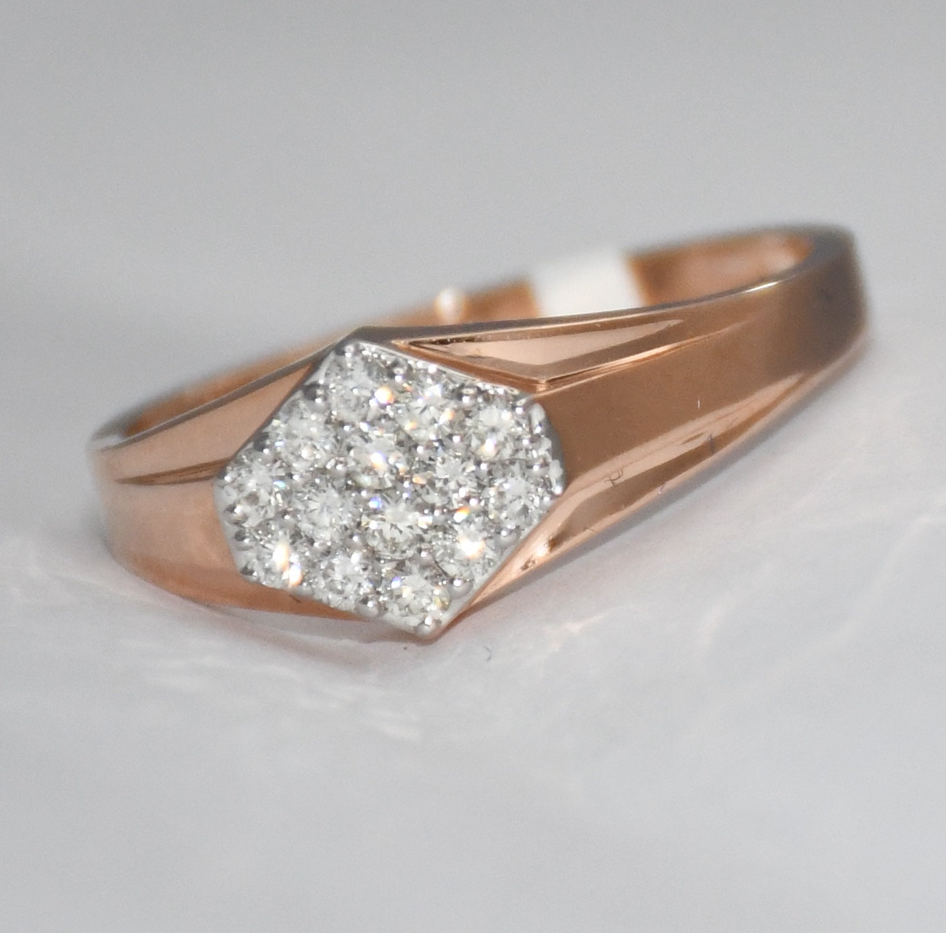 gold ring with a diamond on a light gray background