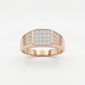 A gold ring with a square pavé diamond center and a small side channel of diamonds, displayed on a white surface against a white background.
