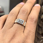 A man's hand displaying a cluster set diamonds ring made in gold.