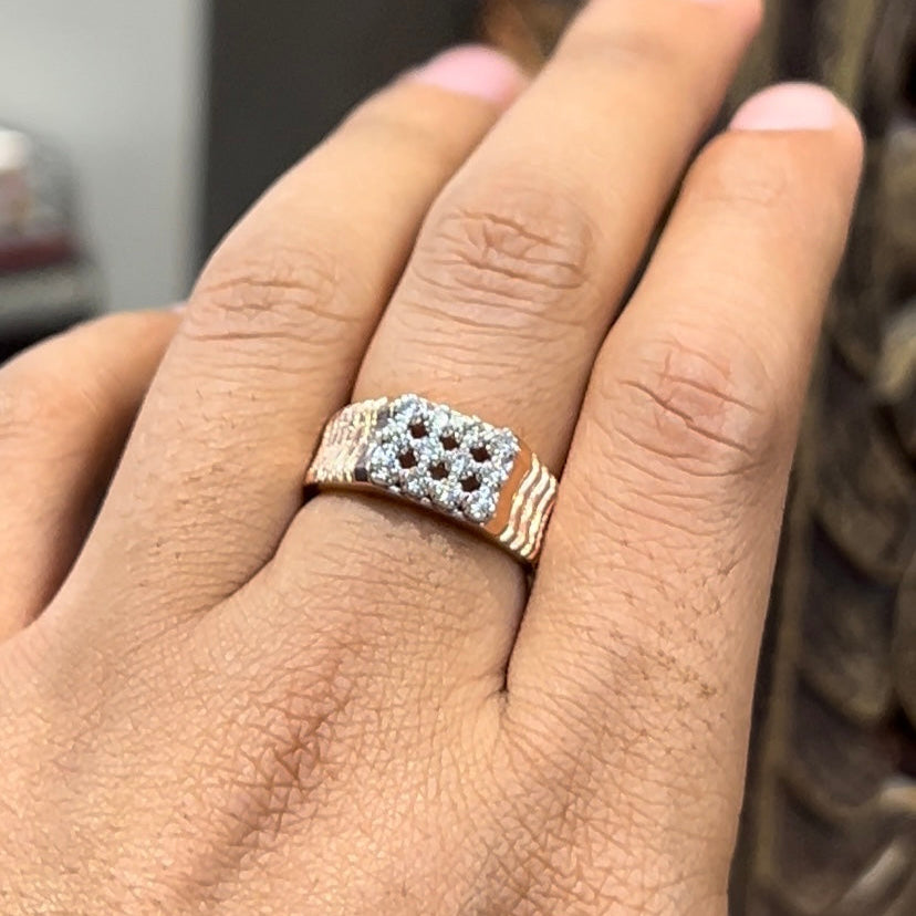 A man's hand displaying a cluster set diamonds ring made in gold.